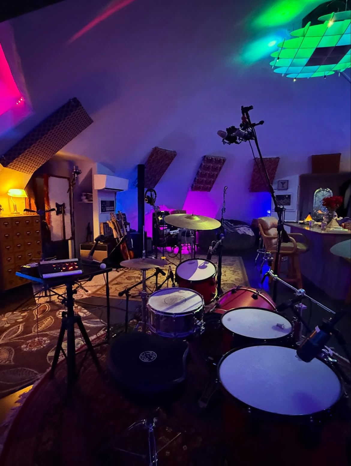Drum kit under colored lights beneath the dome ceiling