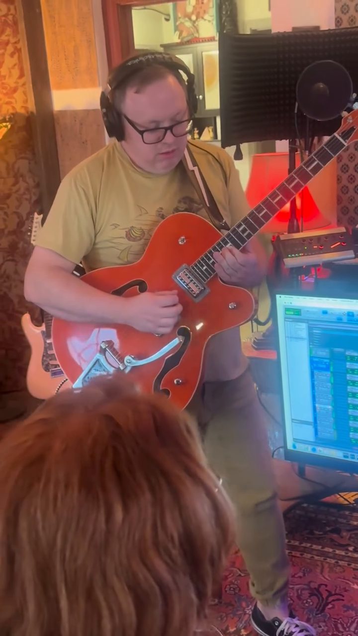 Artist tracking guitar in the control room during a session at The Dome Collective